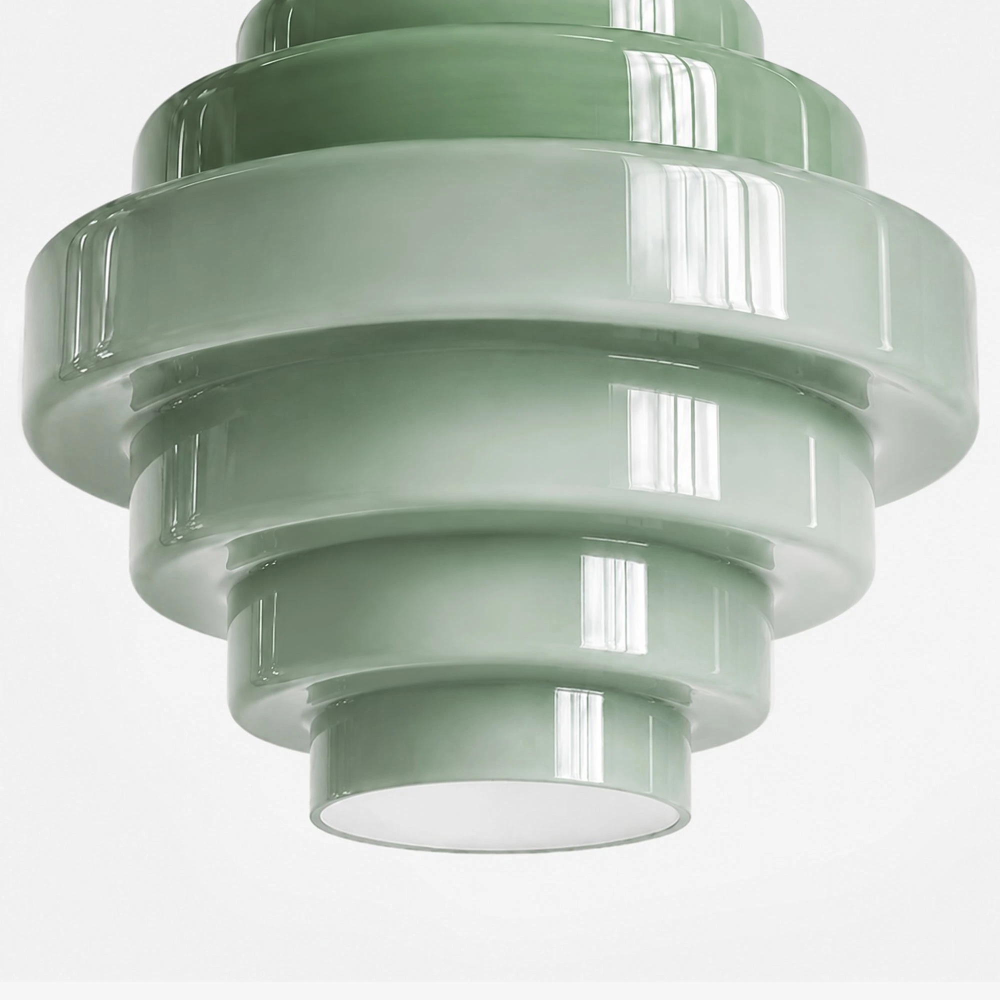Detail van de onderkant van een glazen lampenkap met een gelaagde groene kleurovergang